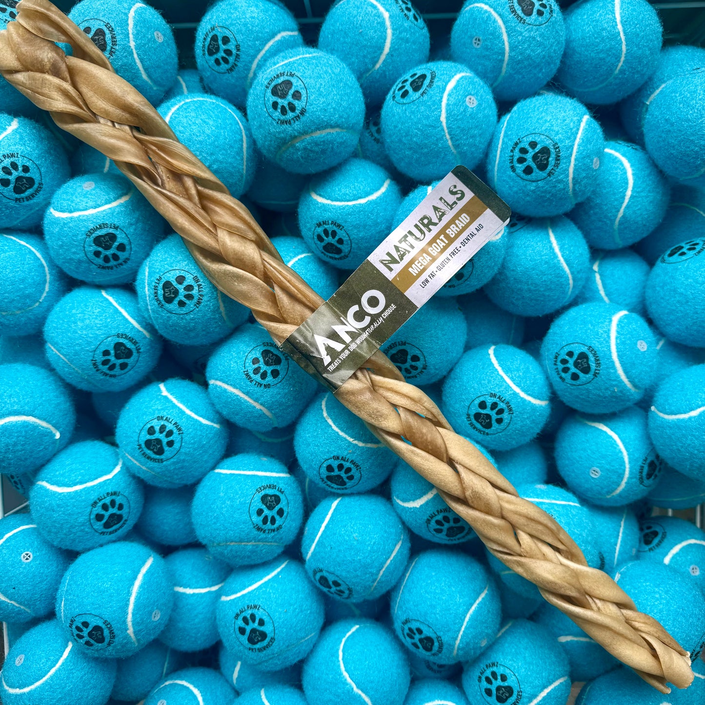 Blue tennis balls with a brown rope toy and Ancol branding on a blue background