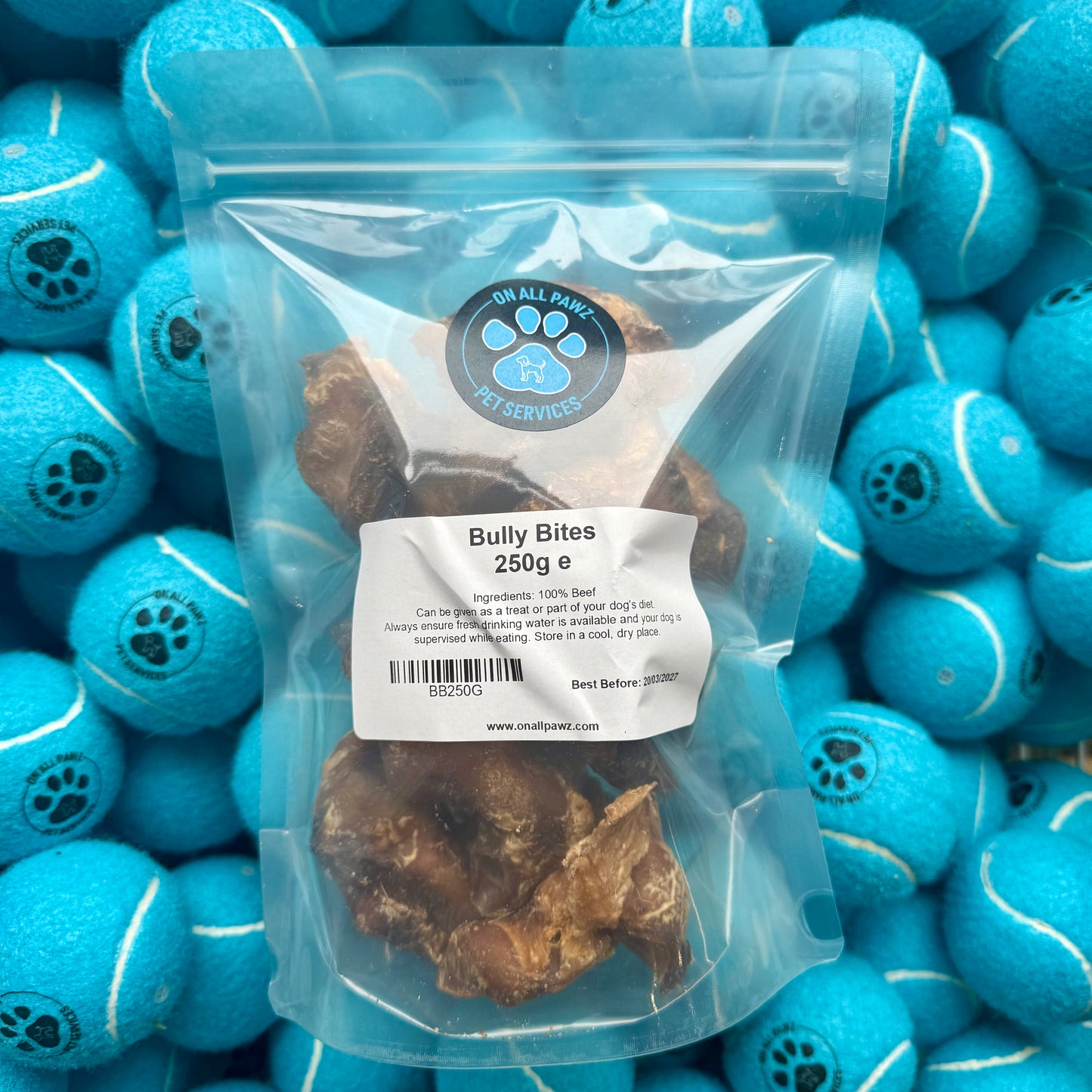 Package of Bully Bites with a label on a background of blue tennis balls