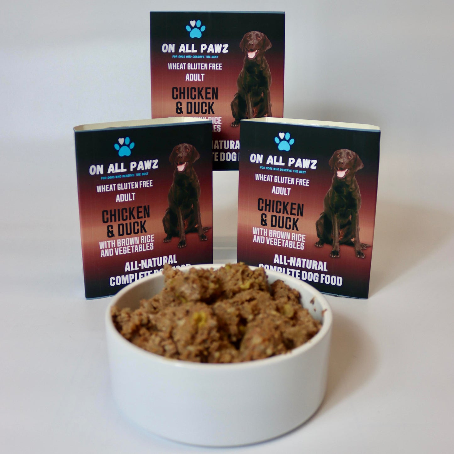 Dog food in a bowl with 'On All Pawz' packaging in the background