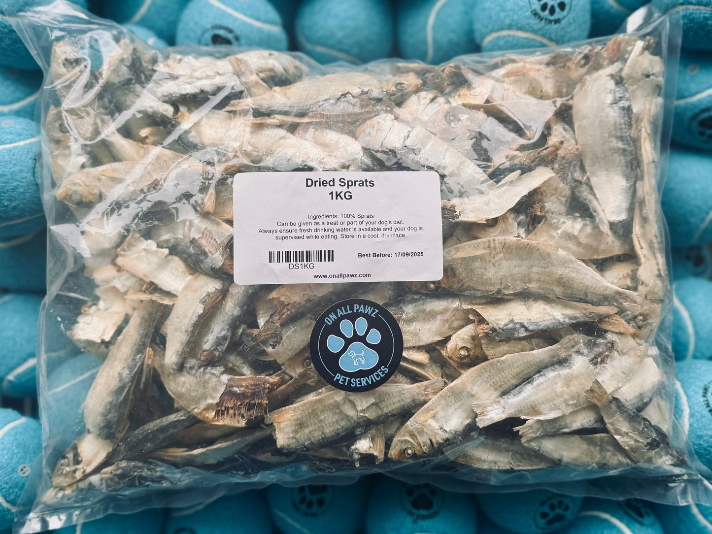 A clear plastic bag filled with dried sprats, with a label indicating the product is for dogs.