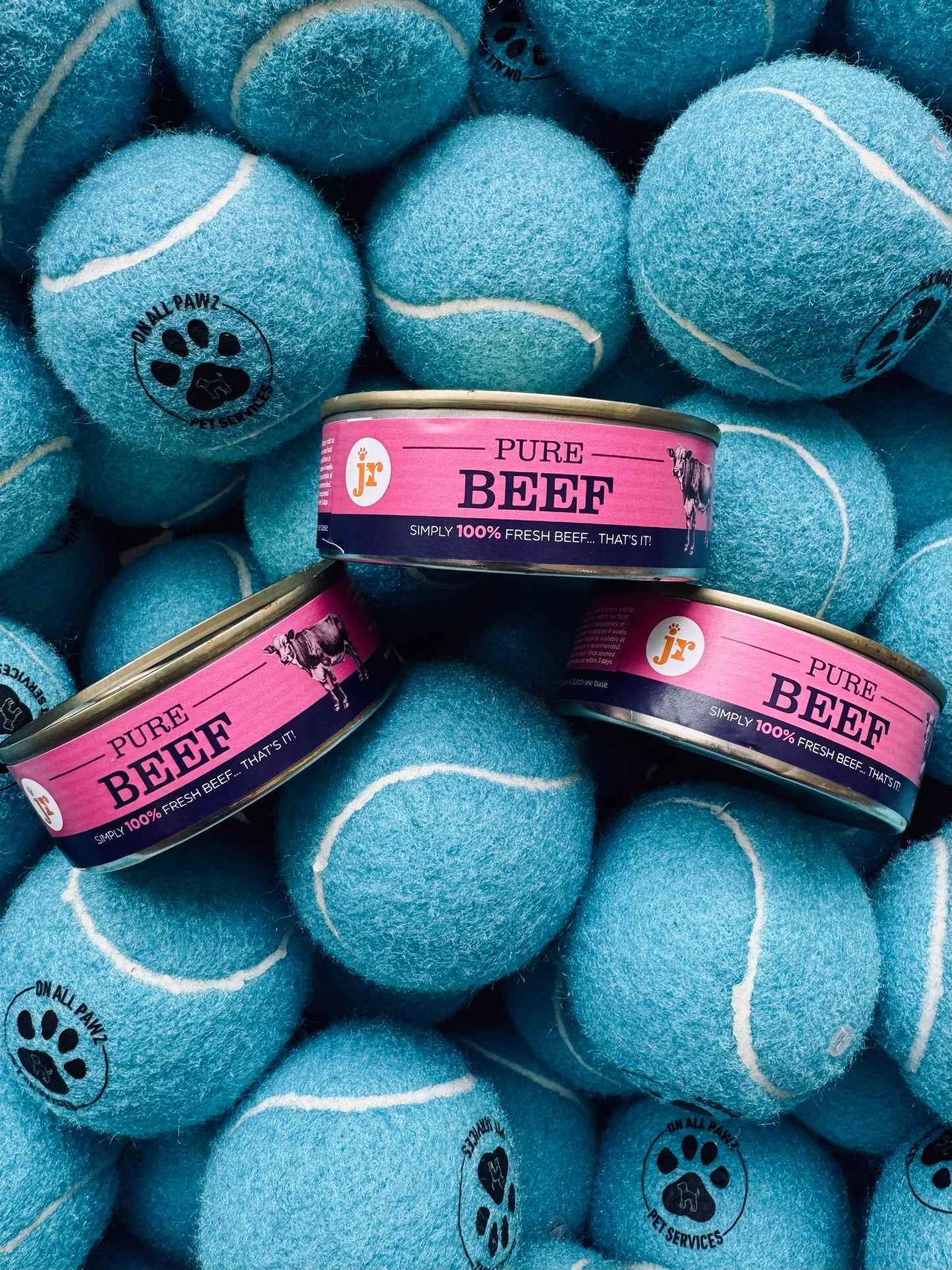 Blue tennis balls with pet food cans on a pile