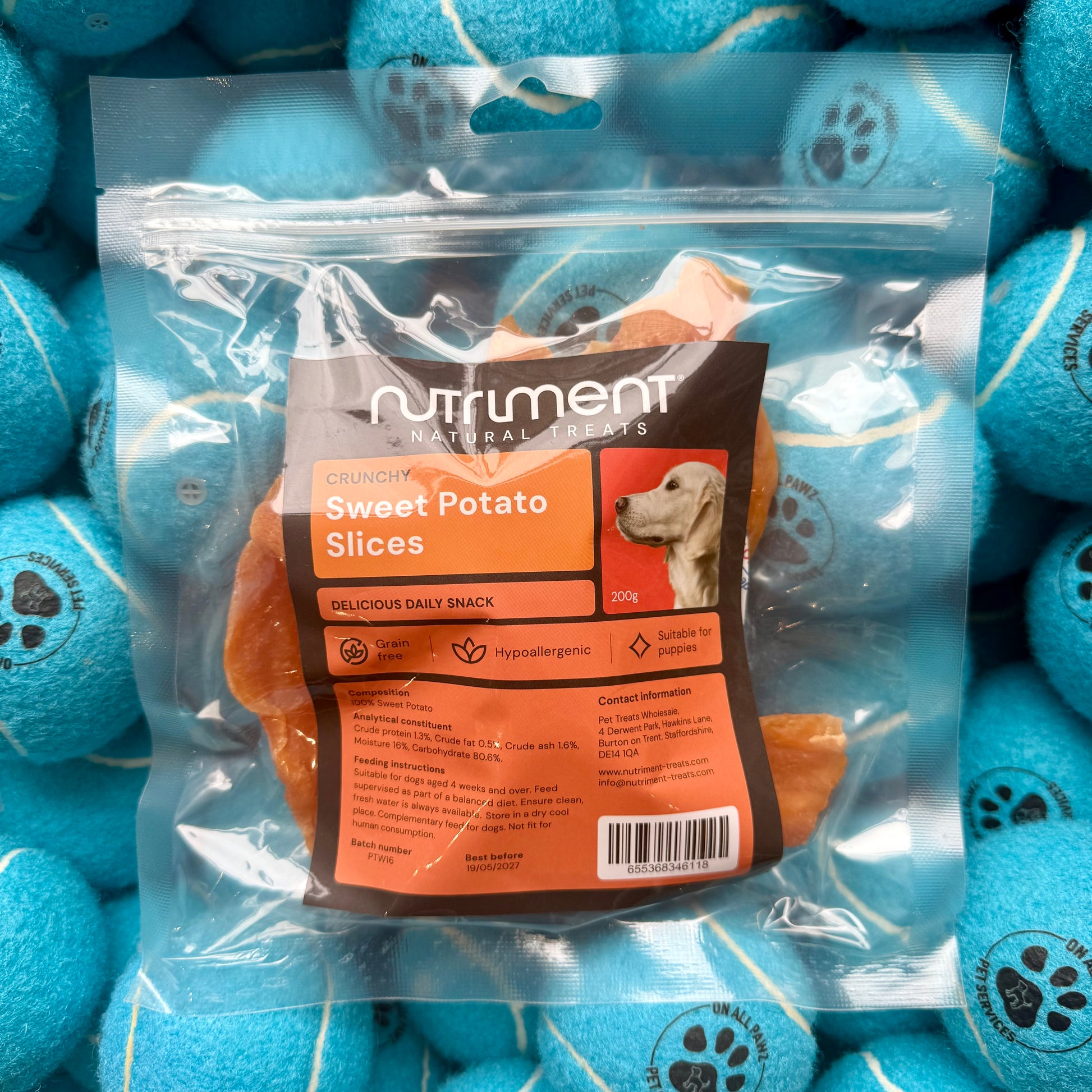 Package of Nutriment Sweet Potato Slices for dogs surrounded by blue balls with paw prints.
