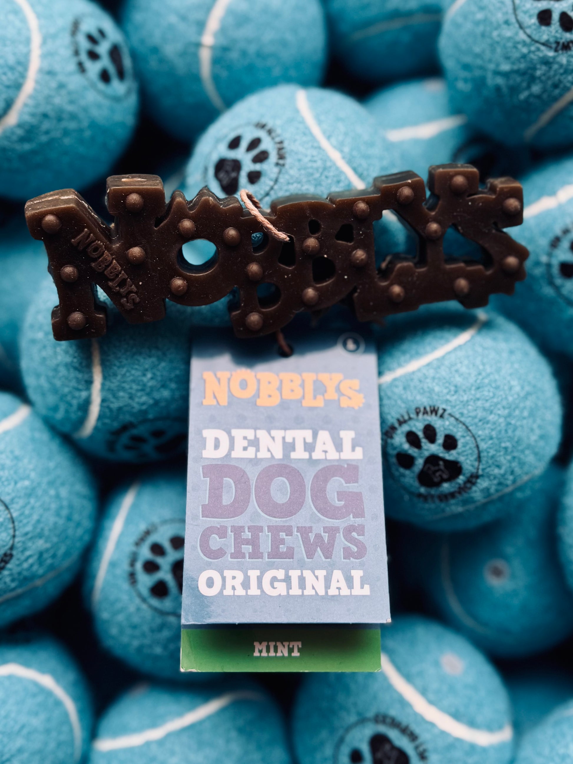 Nobby's Dental Dog Chews Original mint flavor packaging on blue tennis ball background