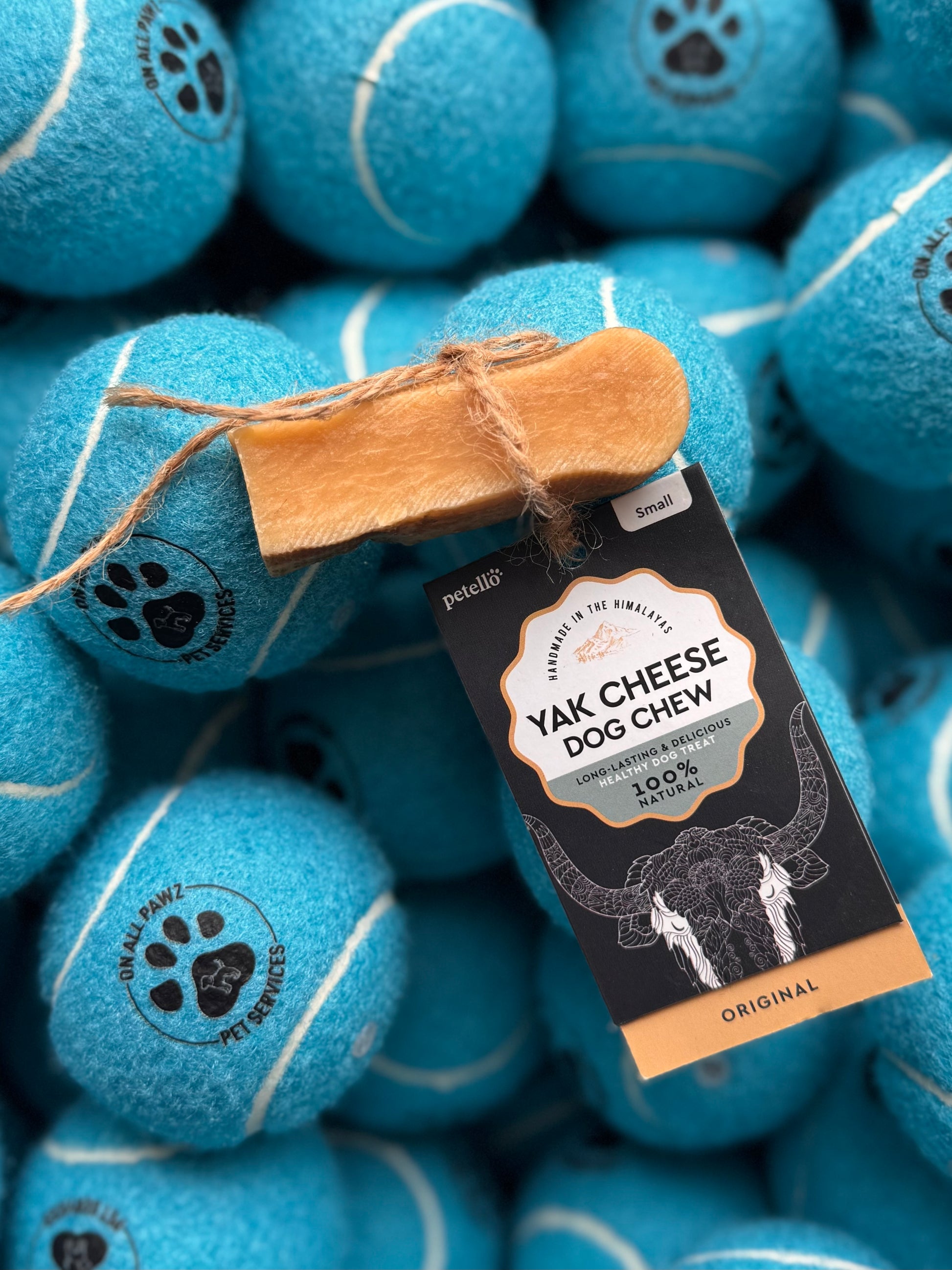 A Yak Cheese Dog Chew treat packaged in a blue tennis ball-shaped container with a label indicating it is original flavor.