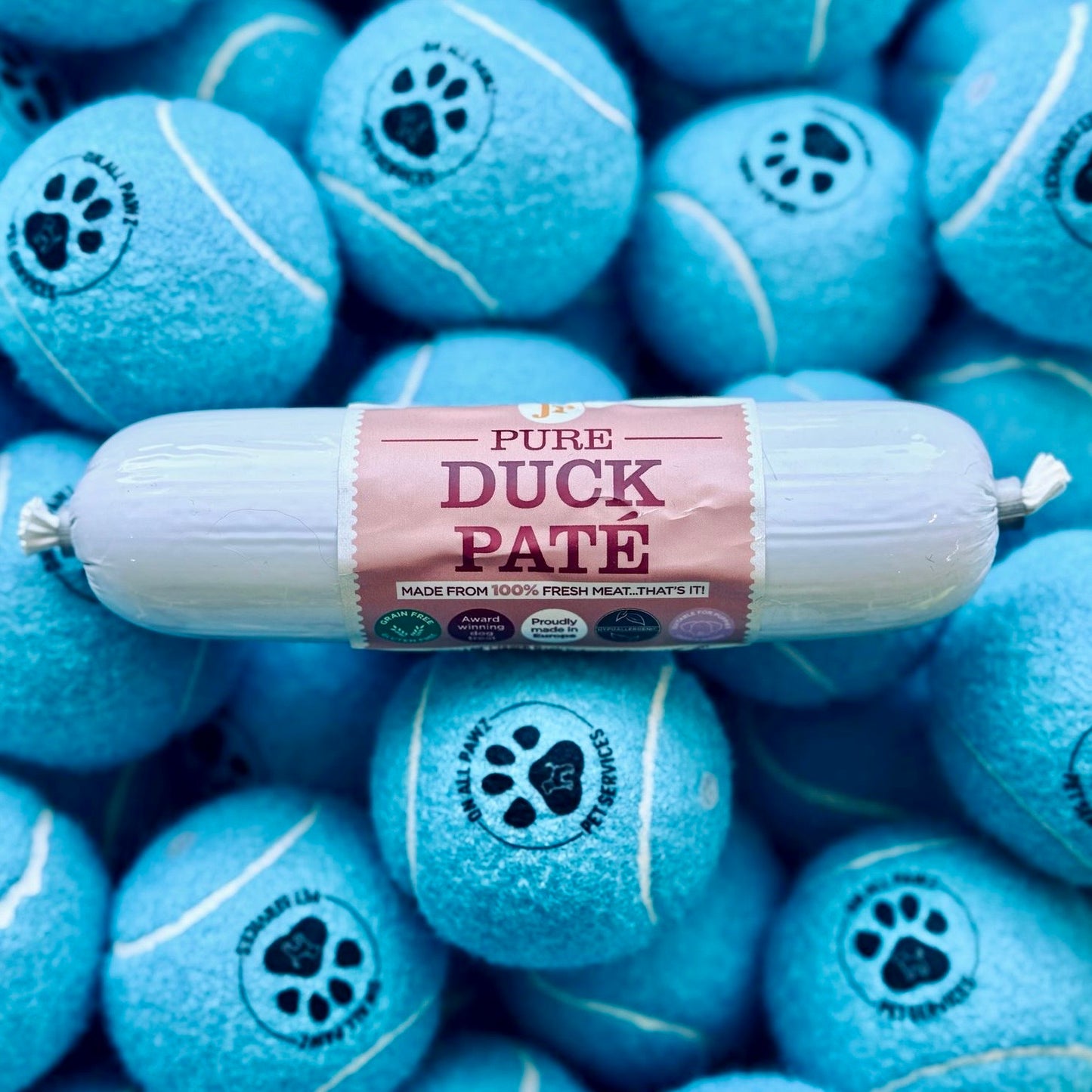Roll of Pure Duck Páté on blue tennis ball treats with paw prints