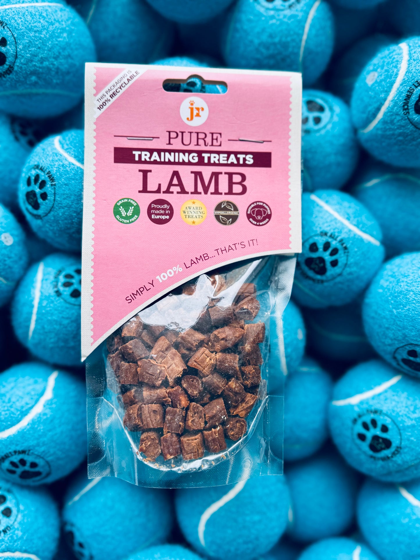 A package of Pure Lamb Training Treats for dogs displayed in front of blue dog toys.