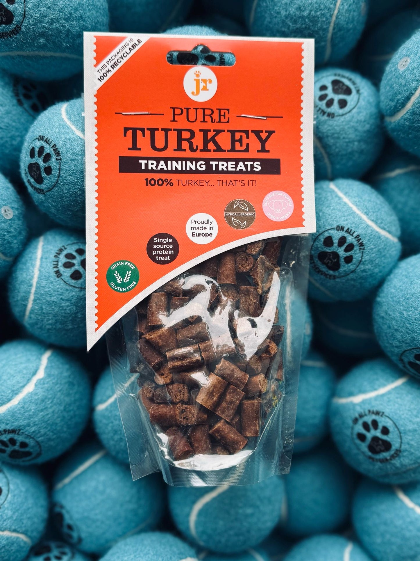 Package of Pure Turkey training treats on a background of blue tennis balls