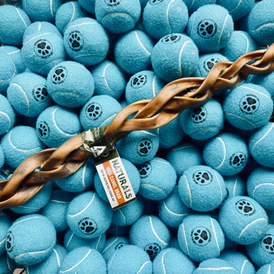 Blue tennis balls with paw prints and a brown rope on top, branded 'Naturals'.