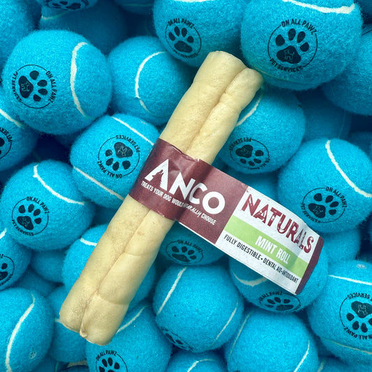 Dog chew toy with ANCO Naturals label surrounded by blue tennis ball dog toys.