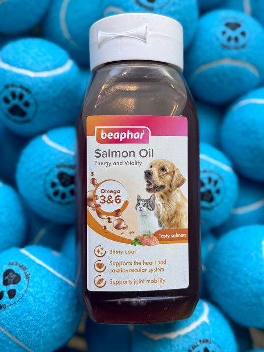 A bottle of Beaphar Salmon Oil with a background of blue pet toys featuring images of dogs and bones.