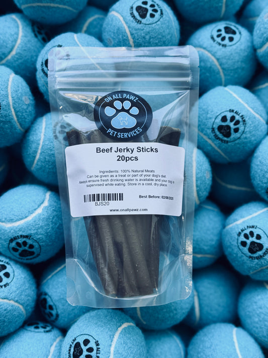 A pack of beef jerky sticks in a transparent plastic packaging, placed on a background of blue dog toys with a paw print design.