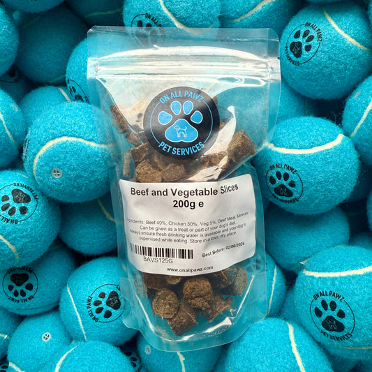Package of beef and vegetable slices on a background of blue tennis balls with paw prints.
