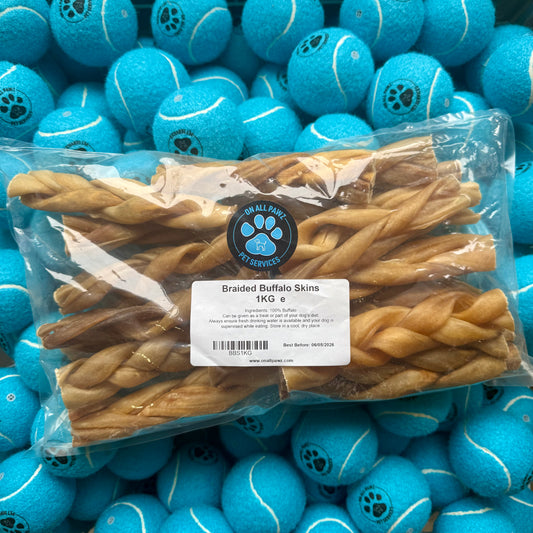 Packaged dog treats with a label on a background of blue tennis balls