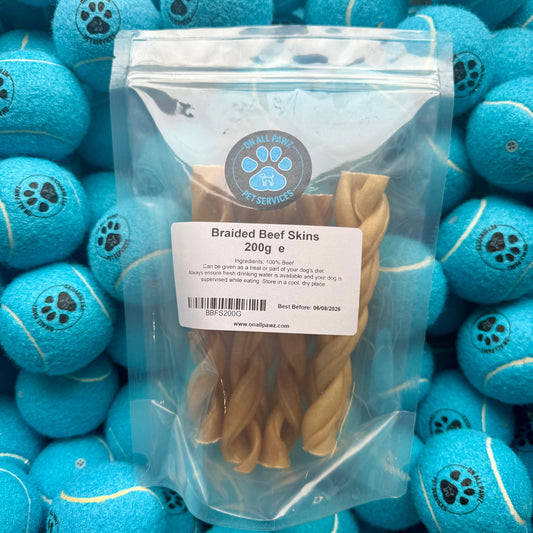 Bag of braided beef skins with a label on a background of blue tennis balls.