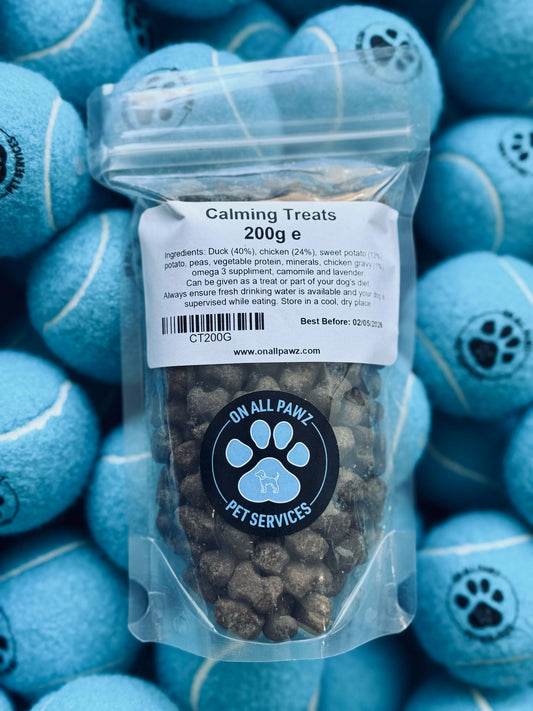 A clear plastic packaging of dog calming treats, labeled 'Calming Treats 200g', with treats visible inside the bag.