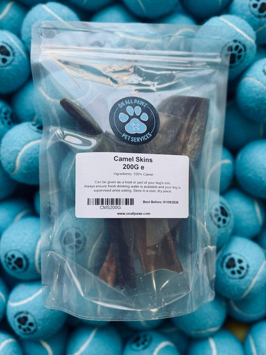 A resealable plastic bag filled with camel skin dog treats, labeled as 200g, with blue dog toys in the background.
