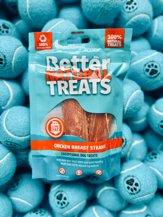 Package of Better Natural Treats chicken breast steaks surrounded by blue tennis balls