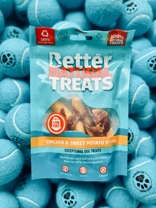 Package of Better Natural Treats chicken and sweet potato sticks surrounded by blue tennis balls.