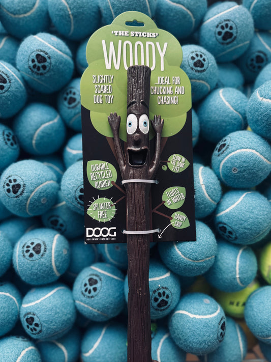 A DOOG Mr. Stick - Woody, a fetch toy for dogs, displayed in front of multiple blue tennis balls.