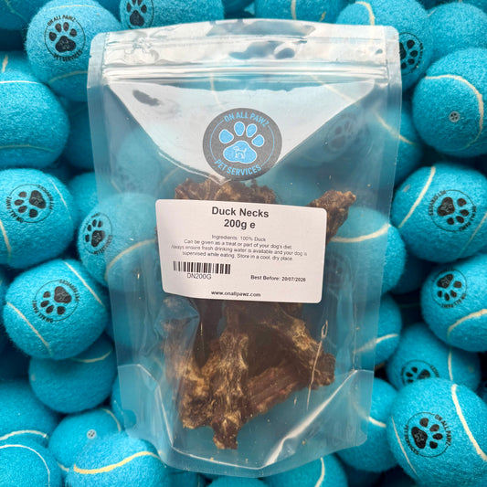 Package of duck necks with a label on a background of blue tennis balls