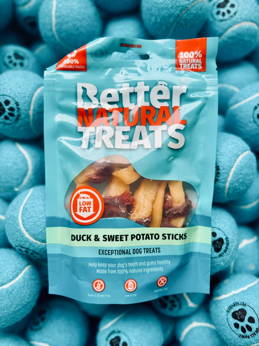 Package of Better Natural Treats duck and sweet potato sticks surrounded by blue tennis balls.