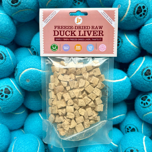 Packaged freeze-dried raw duck liver with a pink label on a background of blue tennis balls.
