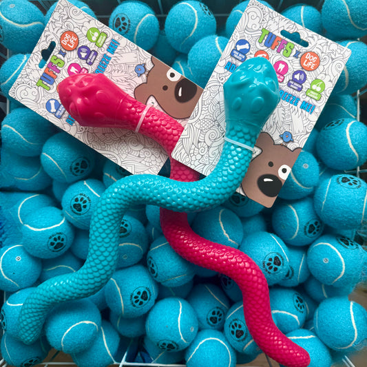 Teal and pink snake toy with packaging on a background of blue balls