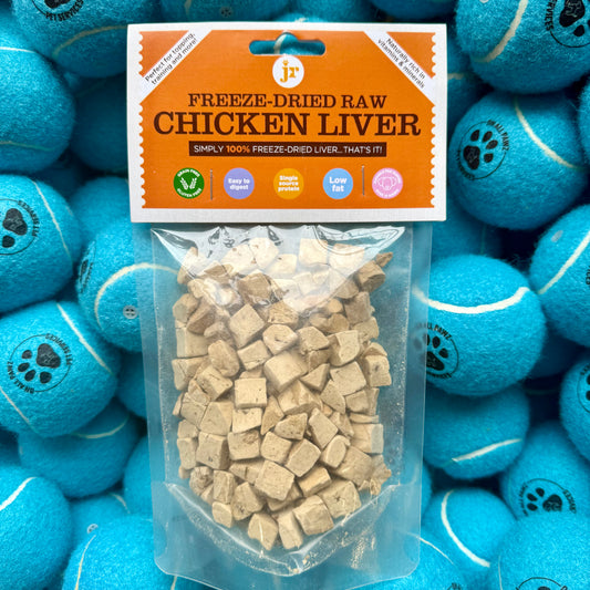 Freeze-dried raw chicken liver package with blue tennis balls in the background