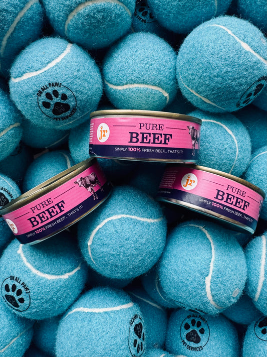 Blue tennis balls with pet food cans on a pile