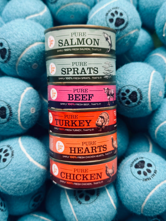 Canned pet food with various flavors surrounded by blue tennis balls with paw prints.