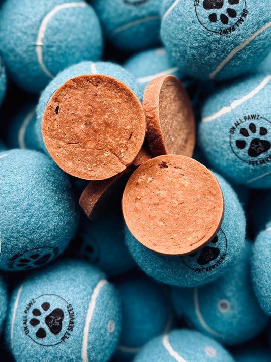 A close-up of JR Pure Lamb Coins, which are dog treats shaped like coins and made from pure lamb meat, displayed against a backdrop of treats with a visible brand logo.