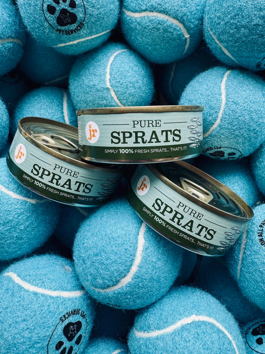Cans of 'Pure Sprats' surrounded by blue tennis balls with paw prints.