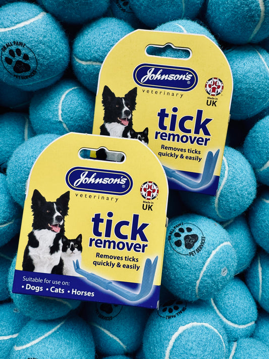 Two packages of Johnson's Veterinary Tick Remover surrounded by blue tennis balls.