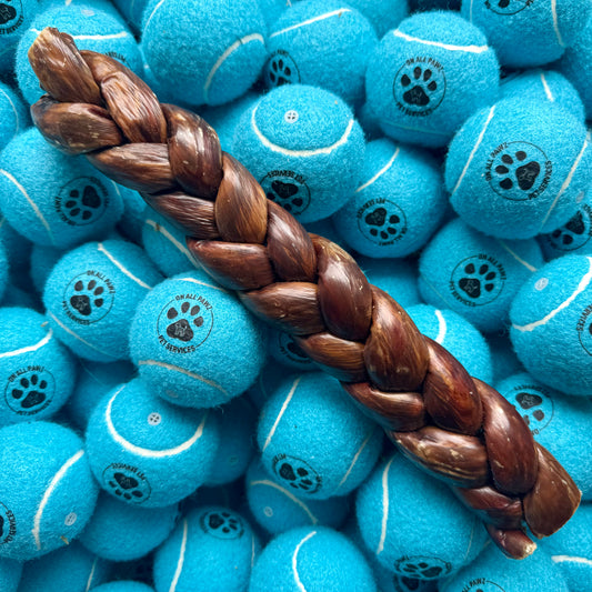 Blue tennis balls with paw prints and a braided brown rope on top