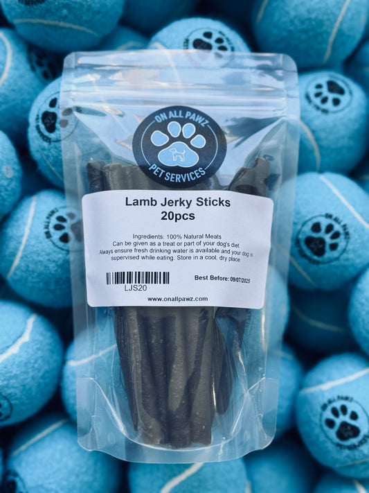 A pack of Lamb Jerky Sticks in a transparent plastic packaging, with blue decorative balls in the background.