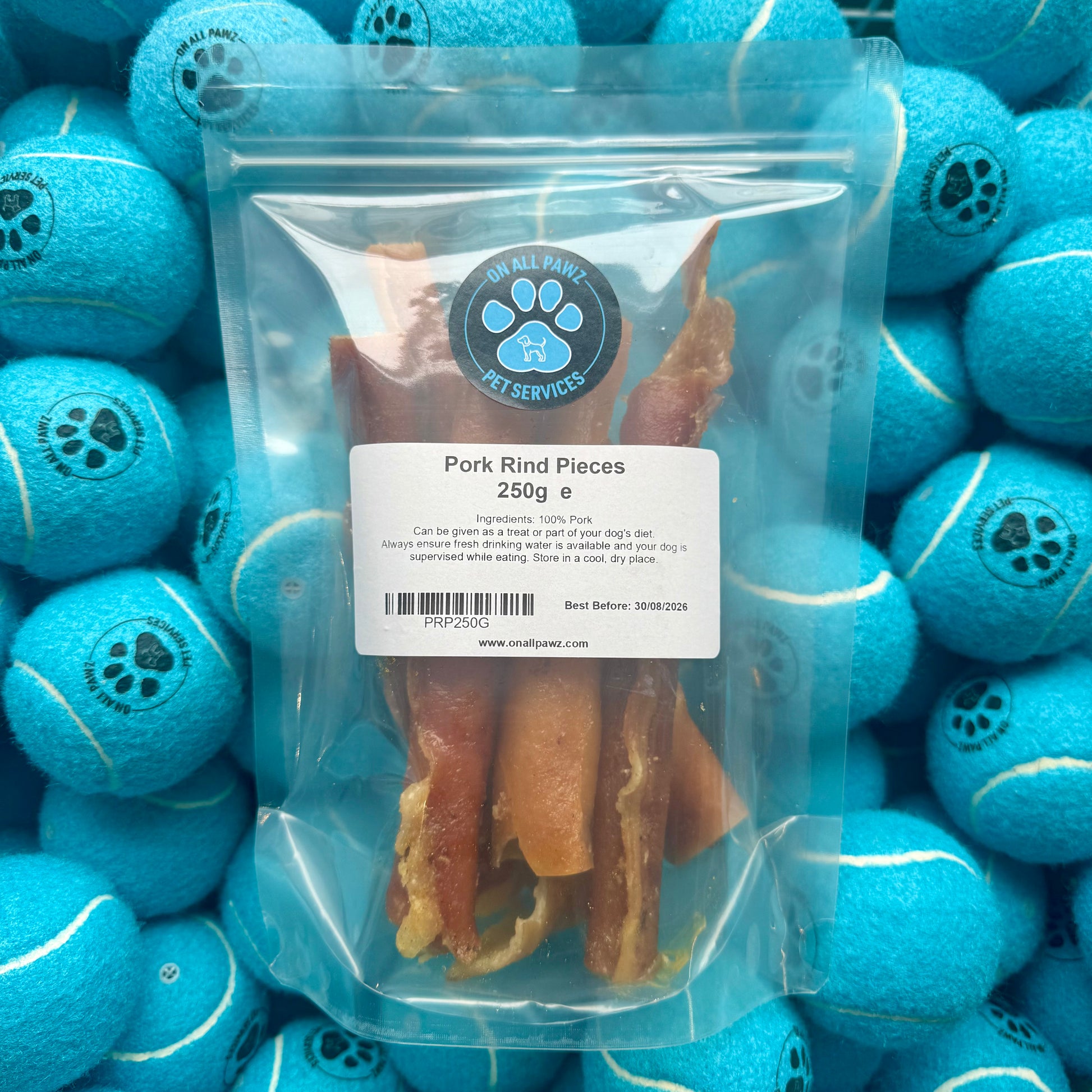 Package of pork rind pieces with a label on blue tennis balls