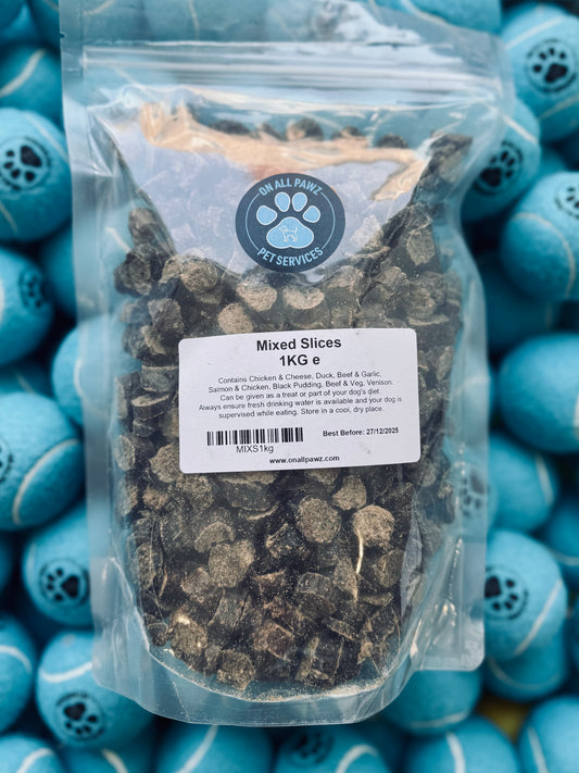 A sealed plastic bag containing dog treats labeled 'Mixed Slices 1KG', with a variety of meats visible through the transparent packaging.