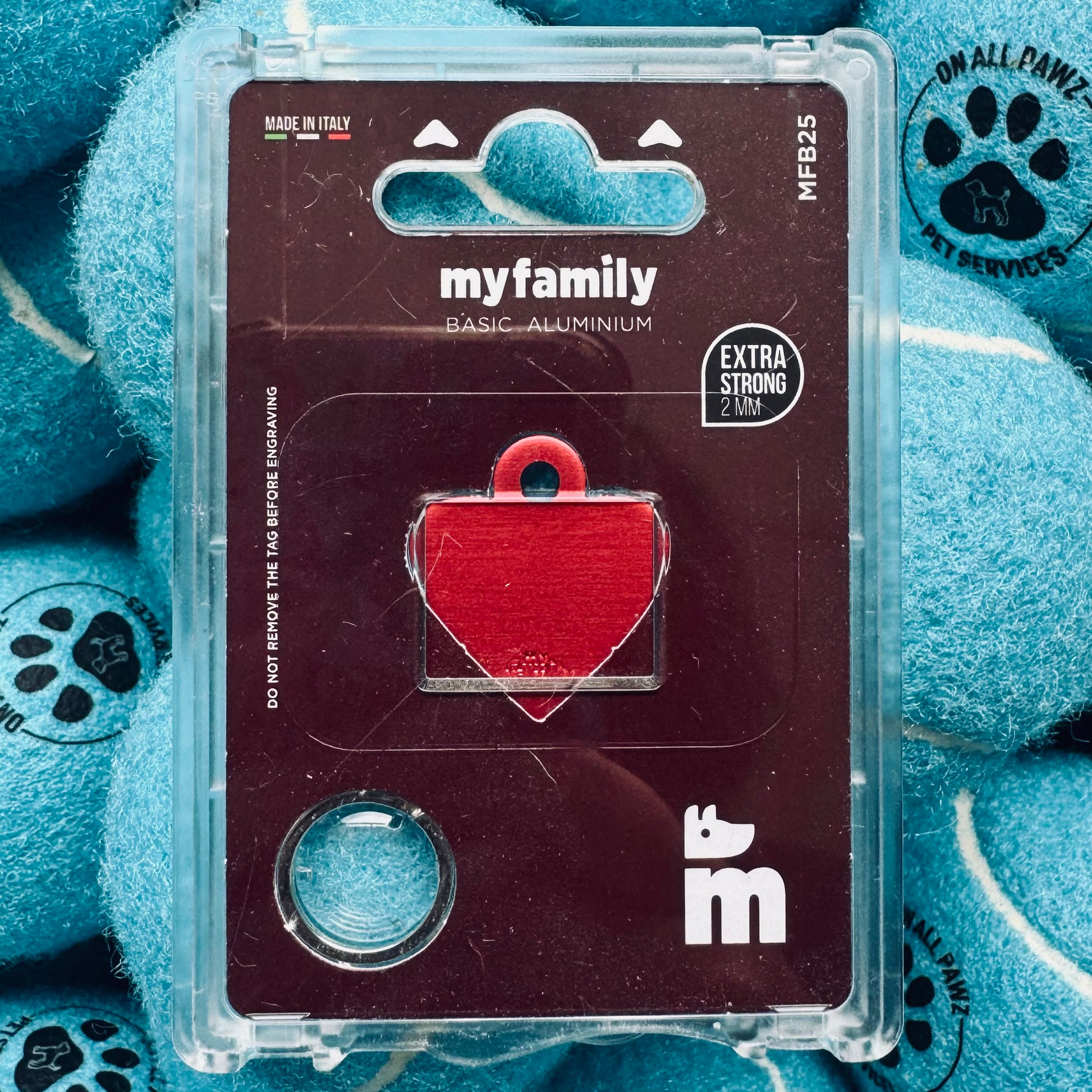 Red heart-shaped pet tag in a clear plastic case on a blue textured background with paw prints.