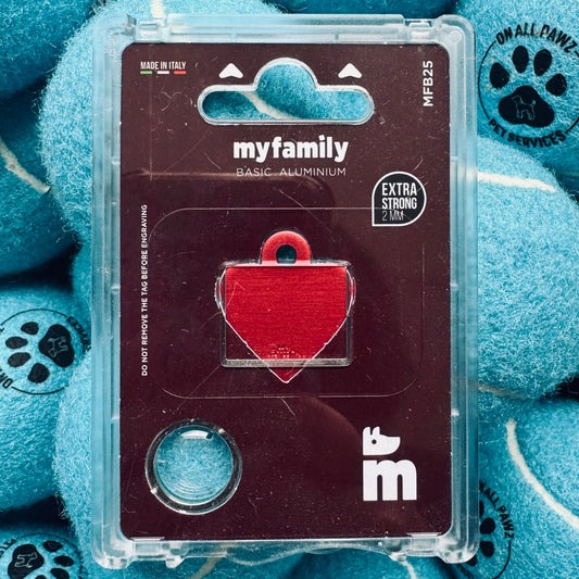 Red heart-shaped pet tag in a clear plastic case on a blue textured background with paw prints.