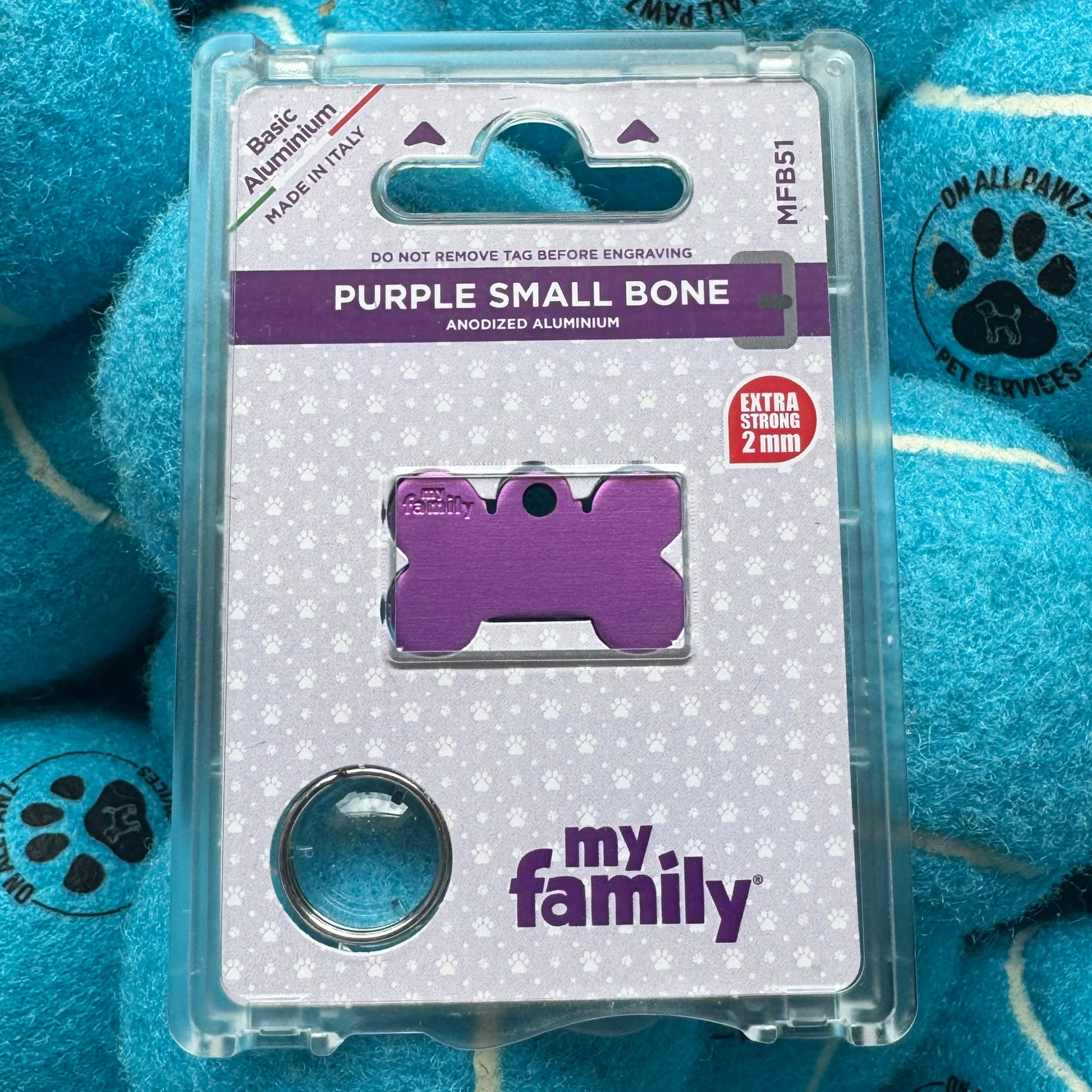 Purple dog tag packaging with 'my family' branding on a blue plush toy background