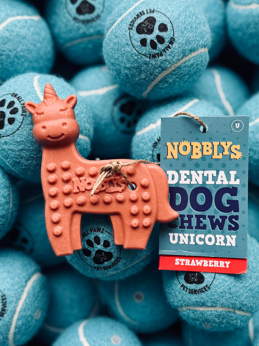 A package of Petello Nobblys Animal Unicorn Strawberry dog treats with a single treat shaped like a unicorn in the foreground.