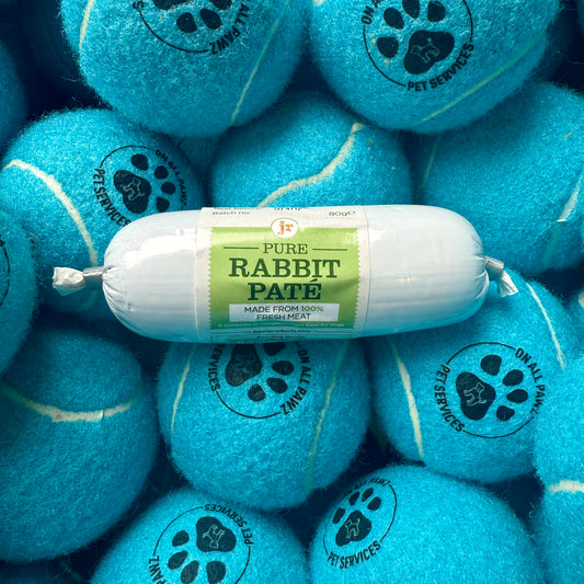 Roll of Pure Rabbit Páte on blue tennis balls with pet services branding