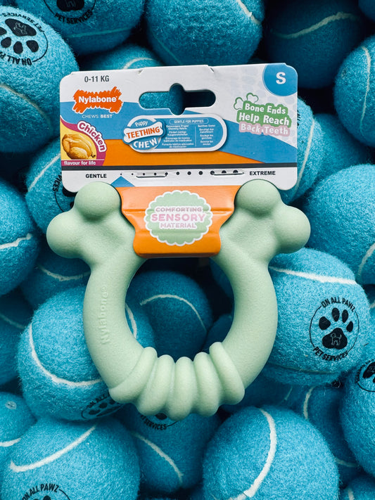 Teething ring with packaging on a background of blue tennis balls