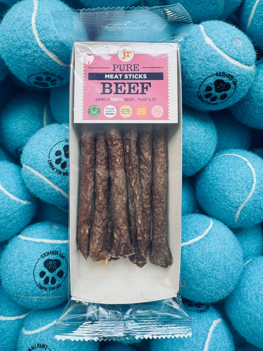 Box of beef sticks with a pink label on a background of blue tennis balls.