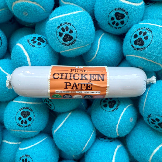 Blue tennis balls with paw prints and a package of 'Pure Chicken Pate' on top.