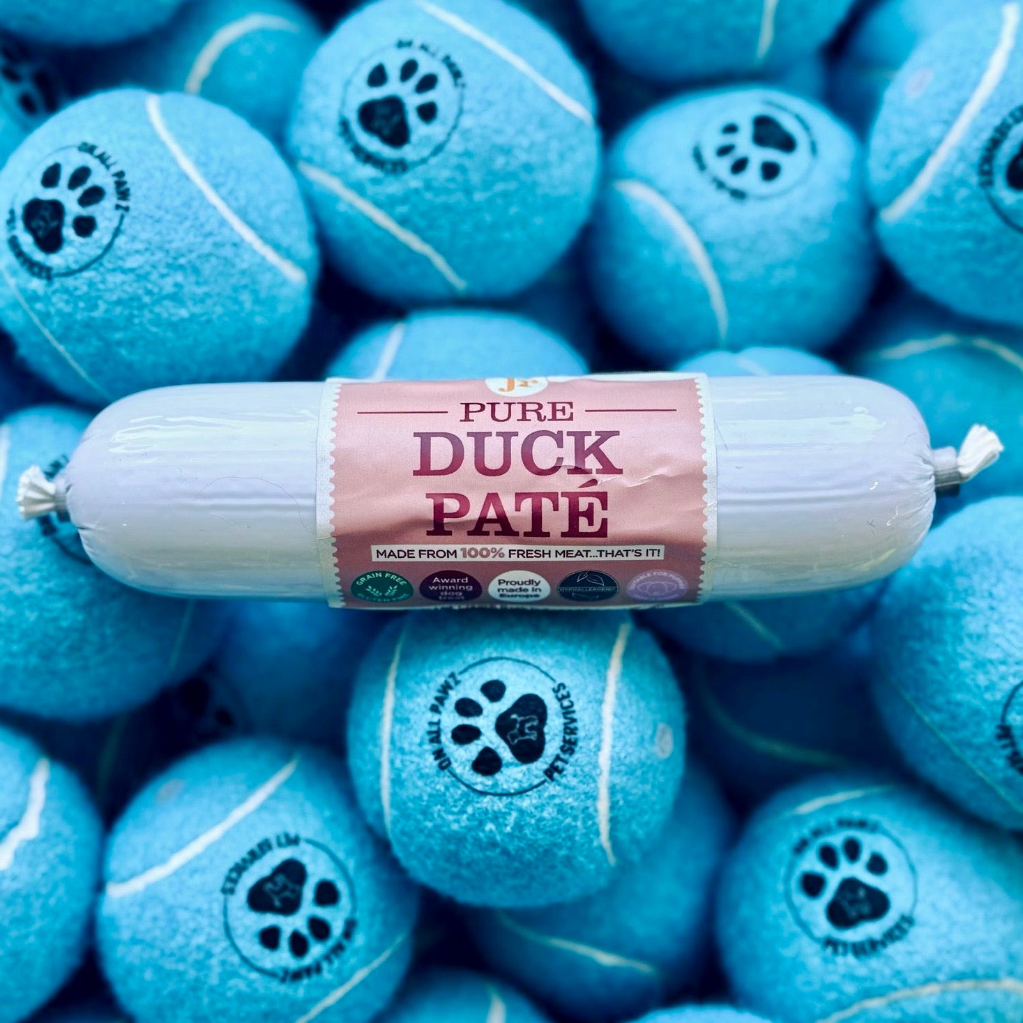 Roll of Pure Duck Páté on blue tennis ball treats with paw prints