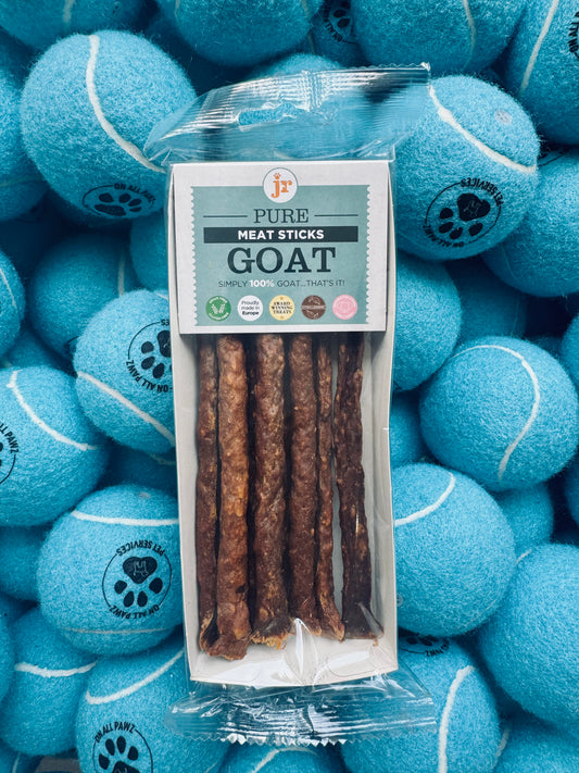 Pack of goat meat sticks with a package labeled 'Pure Meat Sticks Goat' surrounded by blue tennis balls.
