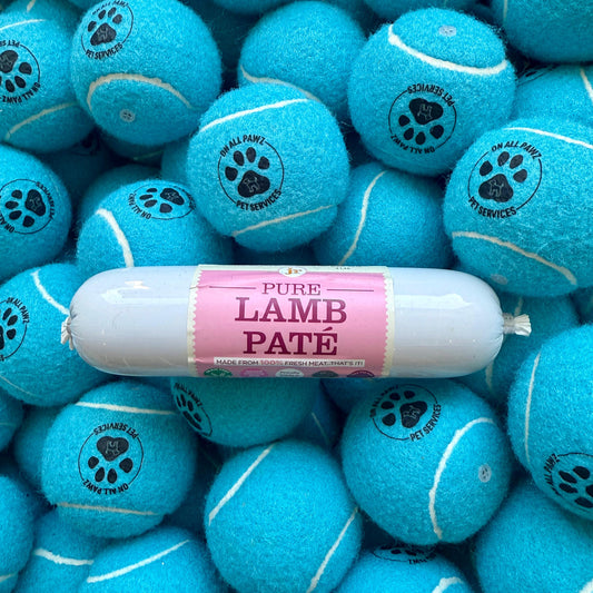 Blue tennis balls with paw prints and a package of Pure Lamb Pate on top.