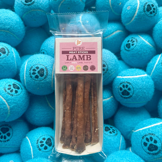 Pack of lamb meat sticks with blue tennis balls in the background