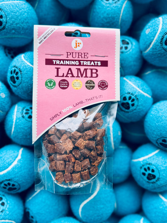 A package of Pure Lamb Training Treats for dogs displayed in front of blue dog toys.